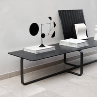 Modern black coffee table with a sleek design, showcasing a minimalist aesthetic against a light gray backdrop.