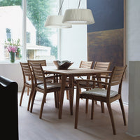 "Minimalist wooden dining set with light beige cushion seats and a neutral palette, complemented by soft pendant lighting."