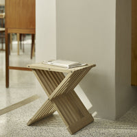 Light wood slatted stool with a natural finish, showcasing a simple yet elegant X-pattern design. Ideal for modern decor.