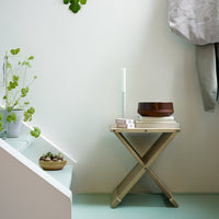 Light green floor, neutral walls, stylish wooden table, and earthy tones with a minimalist decor aesthetic.
