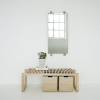 Light wood bench with slatted design, two storage boxes, and a minimalist mirror above, creating a calm, neutral aesthetic.
