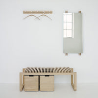 Light wood bench with slatted design, paired with matching storage boxes and minimalist wall hooks against a white background.