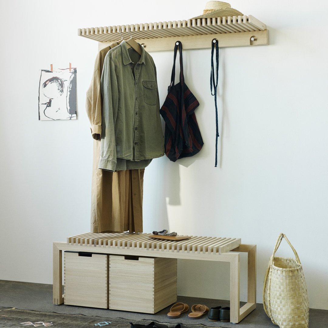 Light wood storage with earthy tones, olive green and rust patterns in a minimalist design showcasing seasonal outfits.