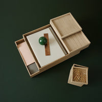 Light wood organizer tray with green and pink accents, featuring clean lines and minimalistic patterns.