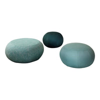 Three round poufs in varying shades of teal, featuring subtle textures and smooth surfaces. Perfect for modern decor.