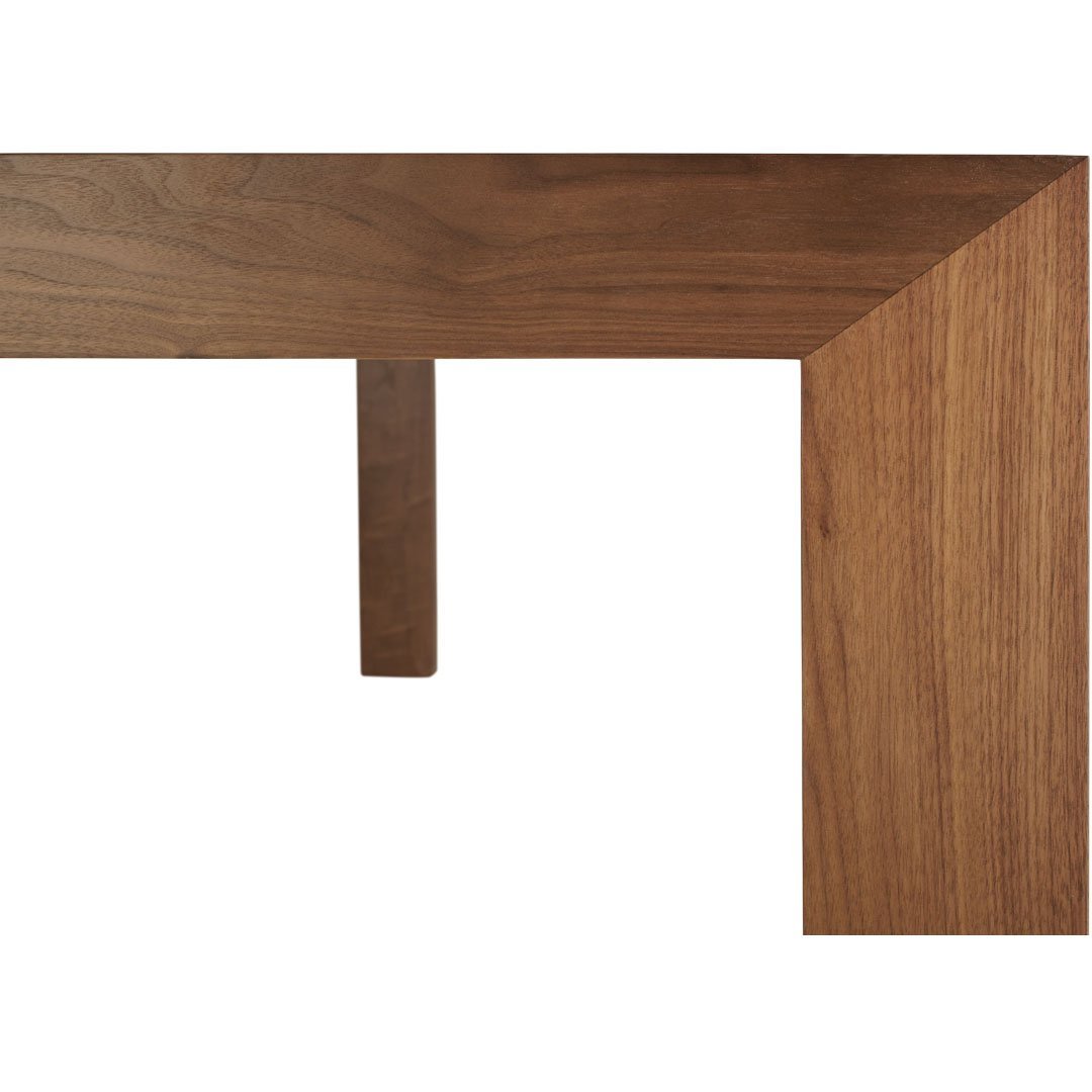 Detailed walnut wood table corner with a rich brown finish and smooth, natural grain pattern. Perfect for modern decor.