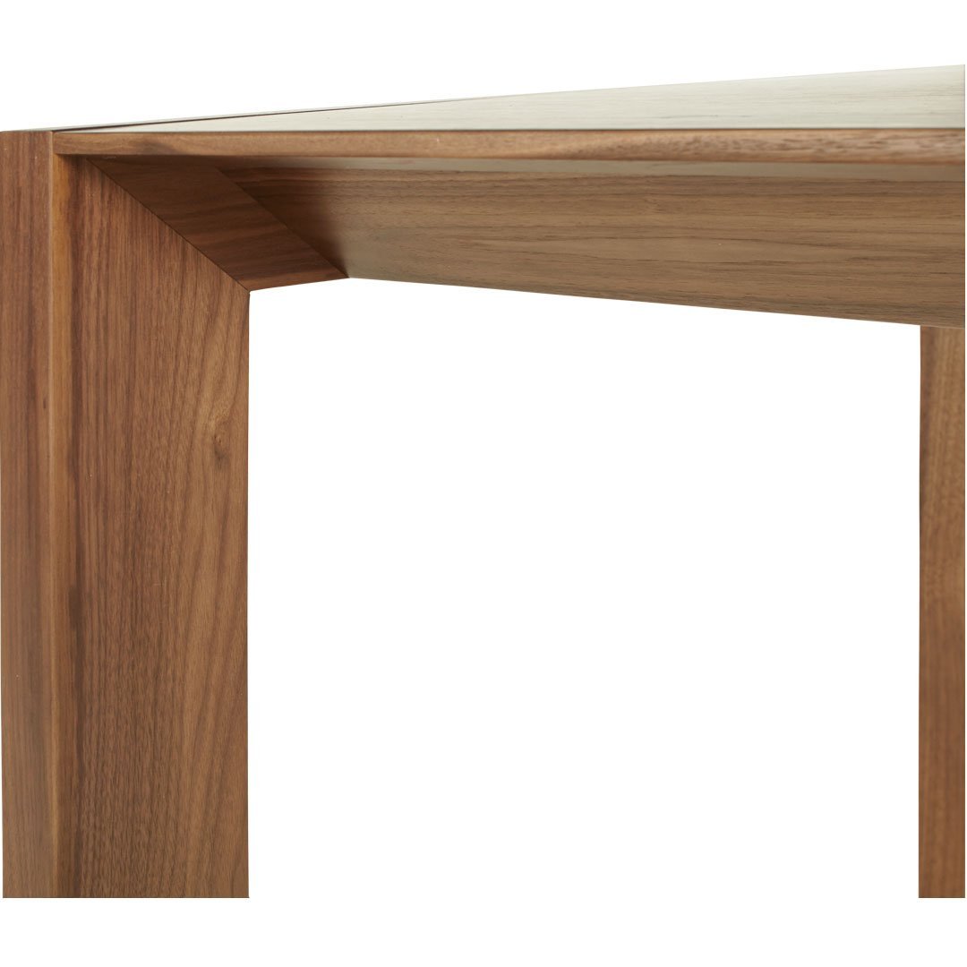 Wooden table corner with a warm walnut finish and smooth, natural grain pattern. Modern and stylish design.