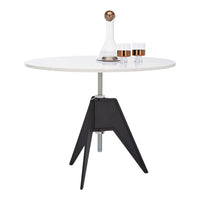 Modern round white table with sleek black tripod legs and copper accents, perfect for contemporary decor.