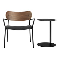 Black metal chair with a curved wooden backrest and simple round black side table. Modern, minimalist design, neutral tones.