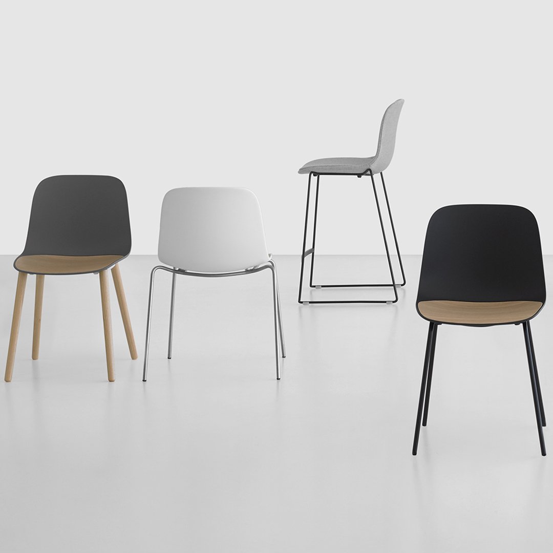 Modern chairs in black, white, and gray with sleek patterns, featuring wooden and metal legs. Minimalist design.