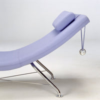 Lavender lounge chair with sleek chrome legs and a matching headrest, showcasing a modern and minimalist design.