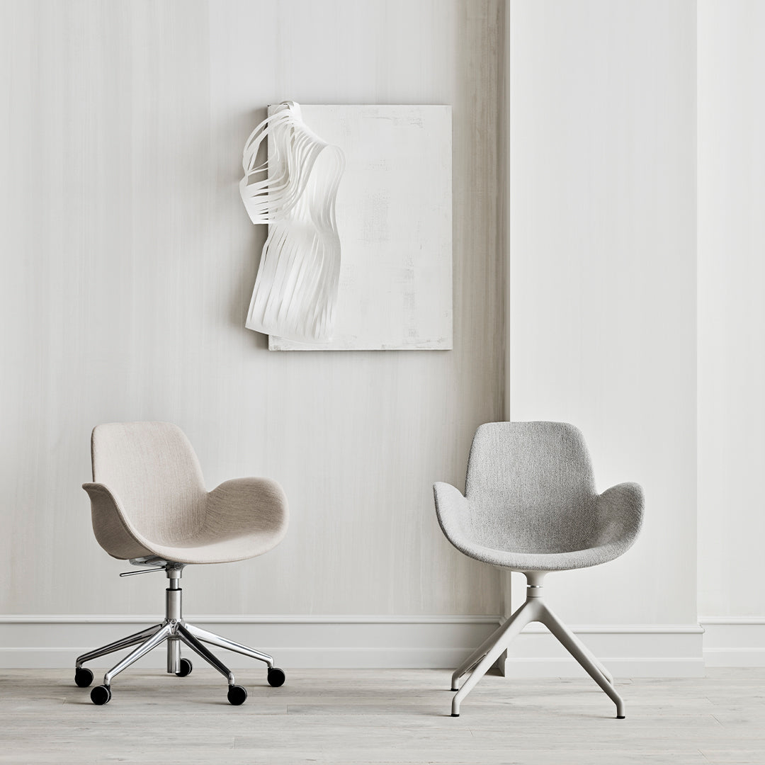 Two modern chairs in soft beige and light gray against a minimalist white backdrop. Sleek designs and subtle colors.