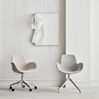 Two modern chairs in soft beige and light gray against a minimalist white backdrop. Sleek designs and subtle colors.