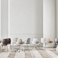 A variety of modern chairs in neutral tones of beige, gray, brown, and white on a textured wooden floor.