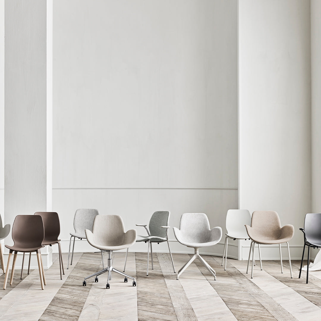 Modern chairs in beige, gray, white, and brown hues against a light backdrop with a wood-patterned floor.