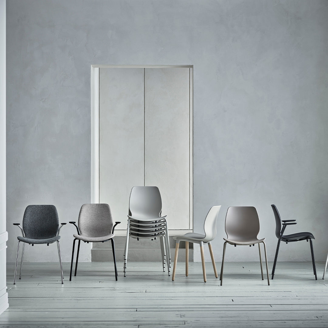 Stylish chairs in various neutral tones: gray, white, and beige, featuring smooth, modern designs against a minimalist backdrop.