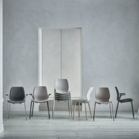 Modern stacking chairs in gray, white, and beige hues, featuring sleek designs against a minimalist backdrop.