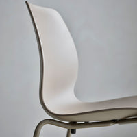 Modern beige chair with smooth curves and a minimalist design, featuring a neutral palette and subtle textures.