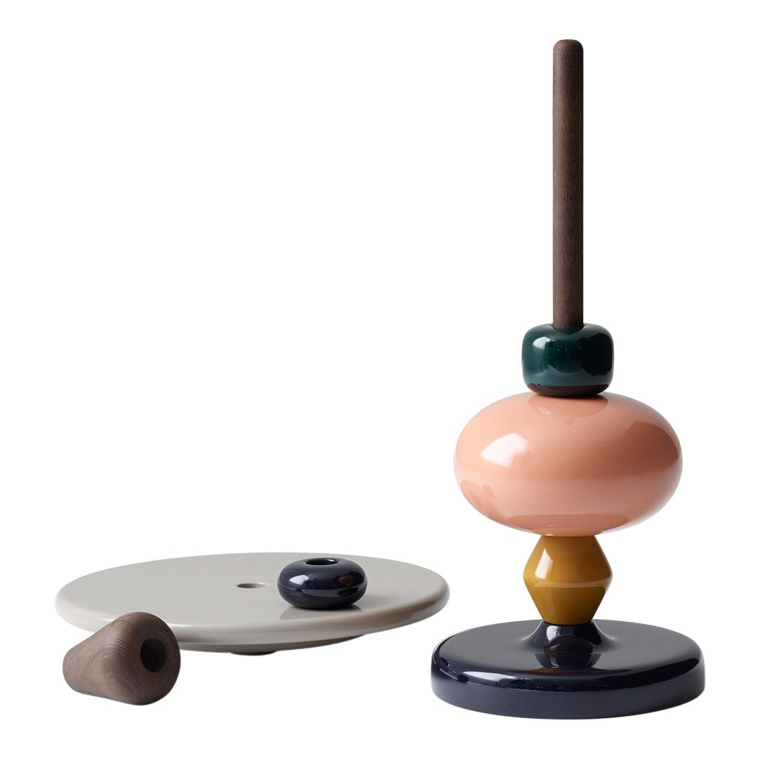 Colorful stacking toy featuring pastel pink, green, yellow, and dark blue patterns on ceramic base.