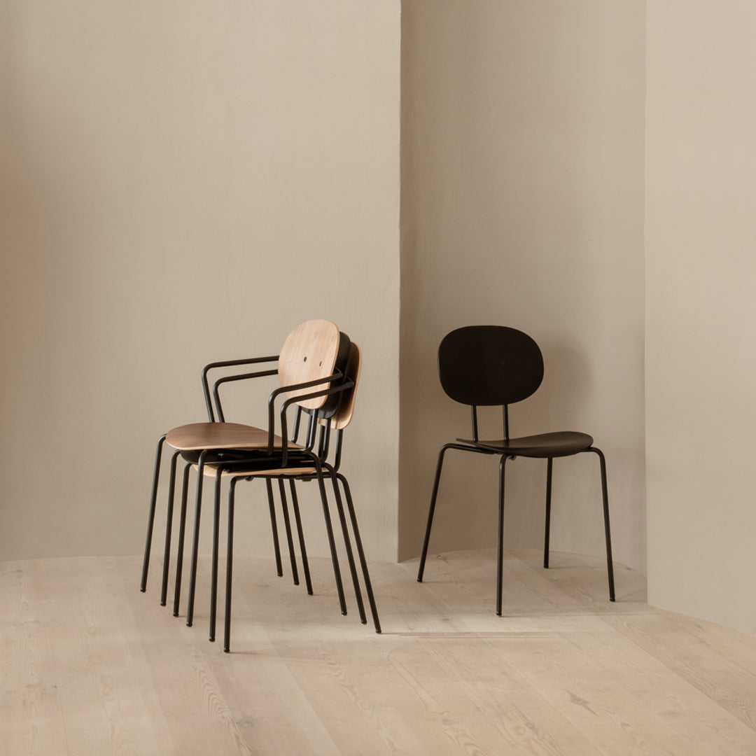 Modern chairs featuring a combination of natural wood and sleek black metal finishes, set against a neutral backdrop.