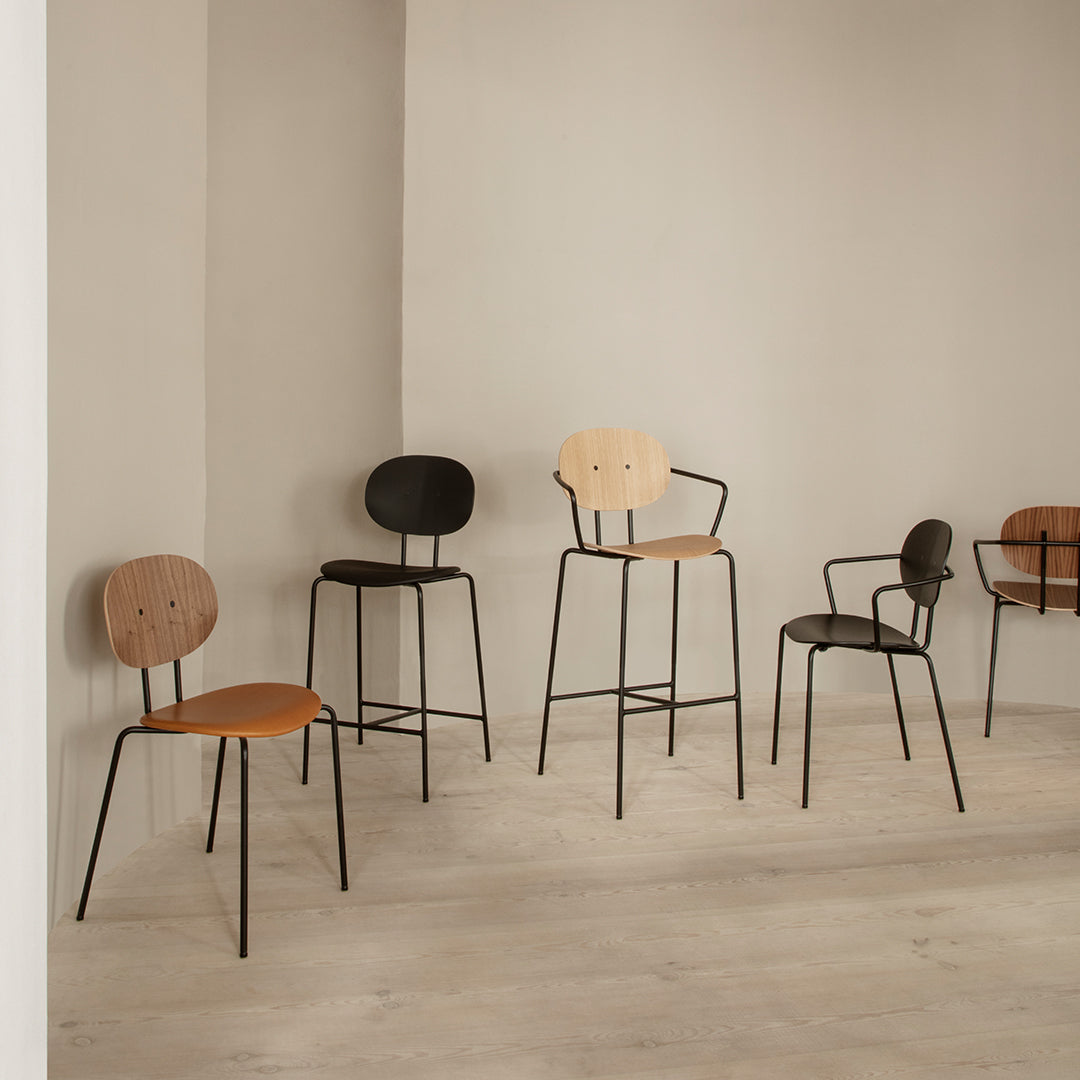 Chic modern chairs in black, light brown, and tan, with minimalist designs, set against a neutral backdrop.