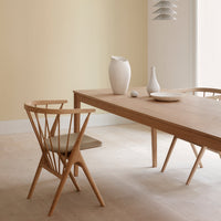 Natural wood tones with a light beige wall and subtle white ceramic vases create a calm, modern aesthetic.