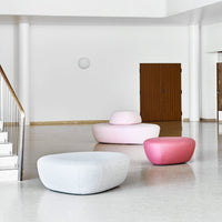 Soft, rounded ottomans in light pink, deep pink, and pale blue shades against a minimalist backdrop.