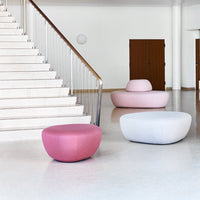 "Round pastel poufs in pink, lavender, and white on a modern stairway backdrop, enhancing contemporary decor."