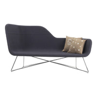 Dark gray modern sofa with a sleek design, featuring a decorative beige pillow with white dots.