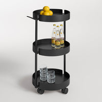 Black metal three-tier rolling cart with circular shelves, featuring glassware and yellow lemons on top.