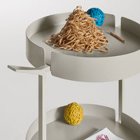 Gray two-tiered tray with vibrant blue, yellow, and natural fiber decorative elements. Minimalist design and soft tones.