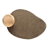 Brown abstract-shaped rug paired with a natural woven bowl, showcasing a minimalist and earthy design.