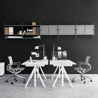 Modern office with gray walls, sleek white desks, and metallic accents, featuring a minimalist design and geometric patterns.
