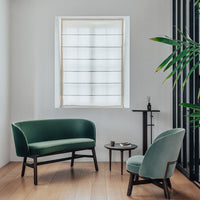 "Elegant green upholstered sofa and chair with a modern design, paired with neutral wood accents and a minimalist decor."