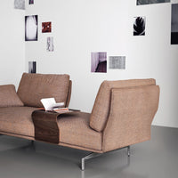 Brown textured fabric sofa with modern design, complemented by minimalist decor on a light wall.