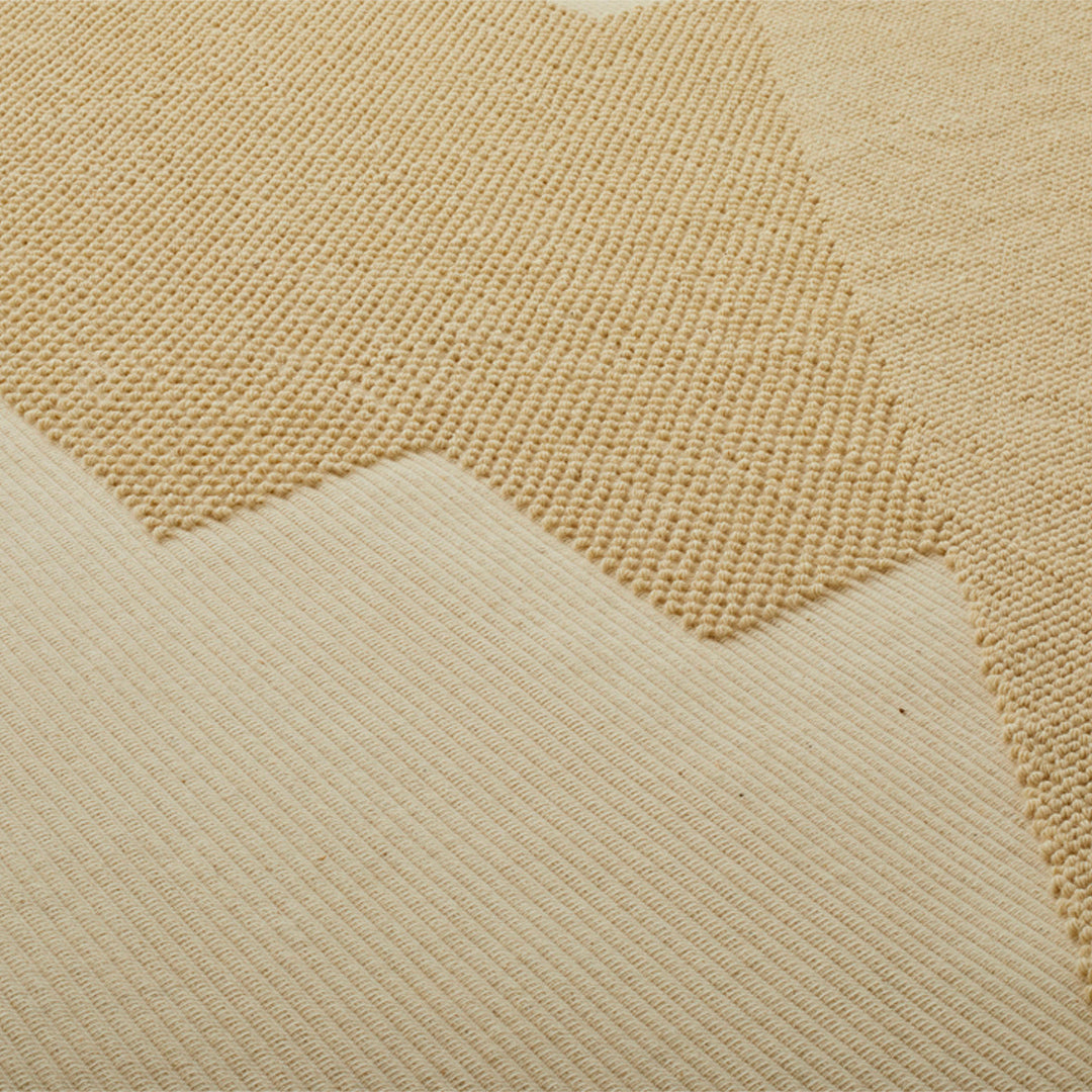 Beige textured fabric with a zigzag pattern, featuring contrasting woven and smooth sections. Ideal for cozy decor.