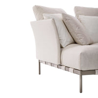 Light beige sofa with plush white pillows and a sleek metal frame, perfect for modern decor.