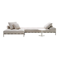 "Light beige sectional sofa with soft cushions and sleek, modern design, complemented by a simple white side table."