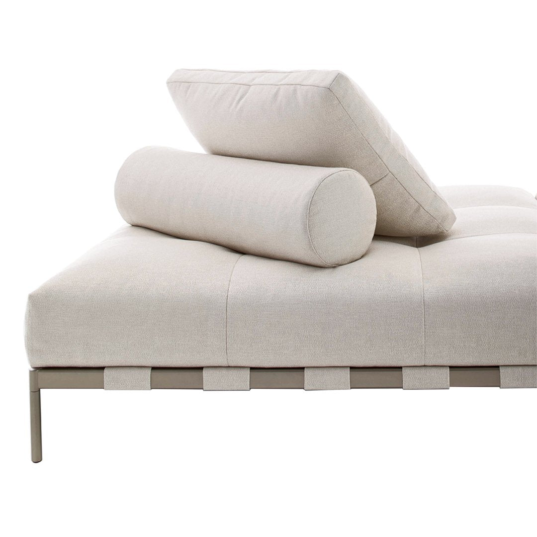 Beige upholstered sofa with a sleek metallic frame, featuring a textured pattern and cylindrical pillows for added comfort.