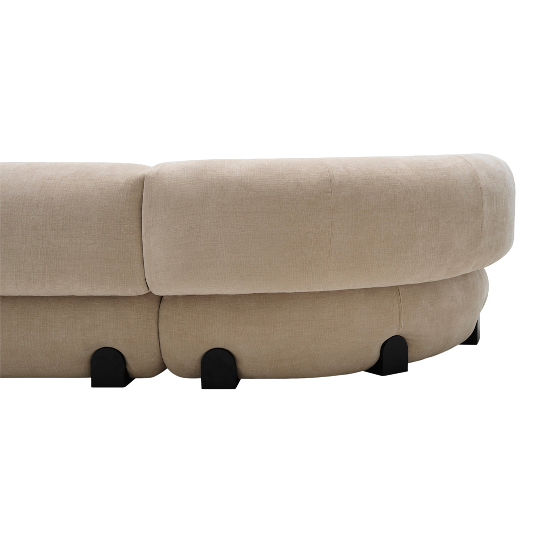 Beige curved sofa with a soft texture and black rounded feet, perfect for modern living spaces.