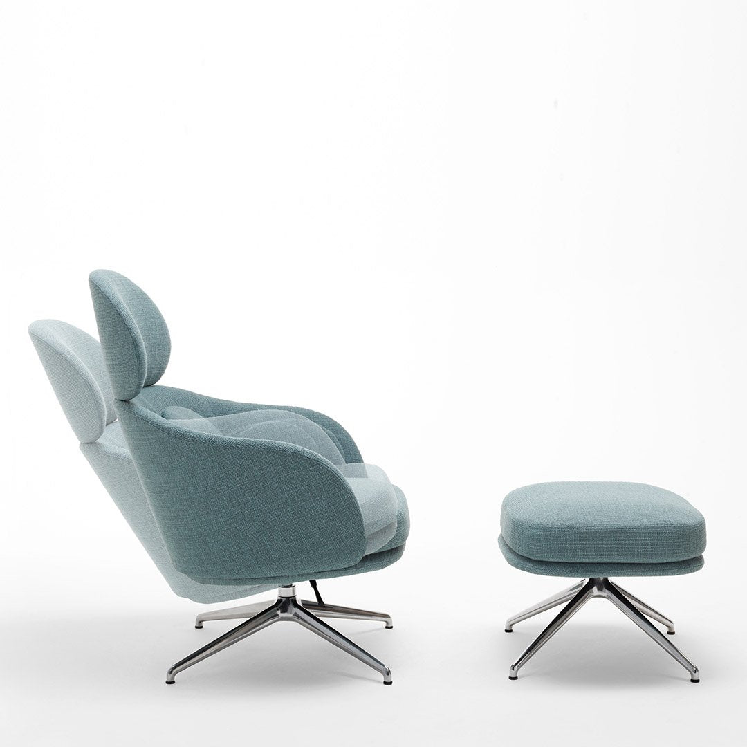 Light blue upholstered lounge chair and ottoman with sleek silver legs, featuring a smooth, contemporary design.