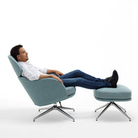 "Light blue modern chair with matching footrest, featuring sleek chrome legs and a minimalist design."