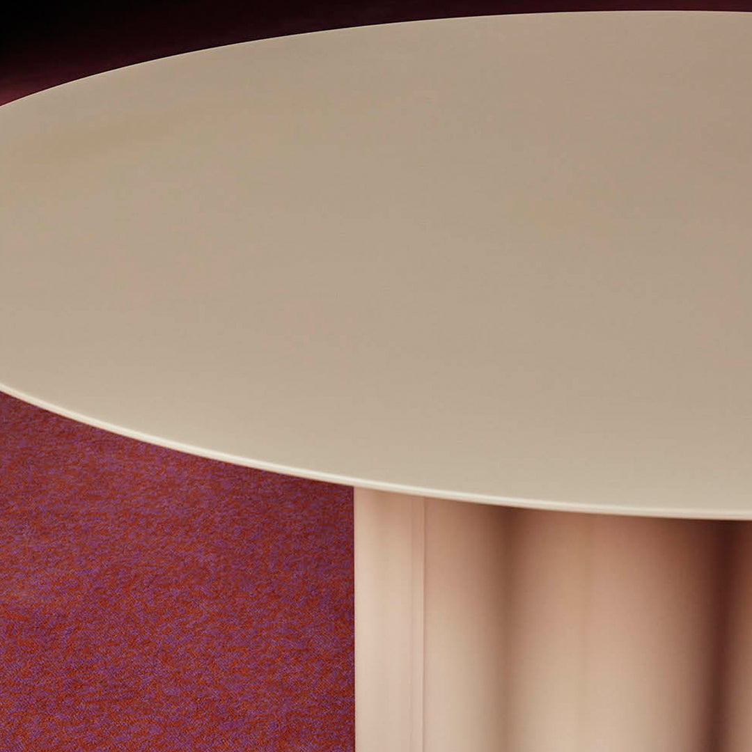 Round beige table on a textured red background, featuring smooth, minimalist design with subtle curved edges.