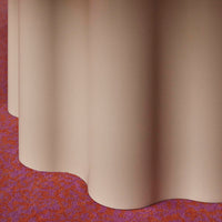 Beige fabric draping over a vibrant red and floral patterned carpet, showcasing soft textures and color contrast.