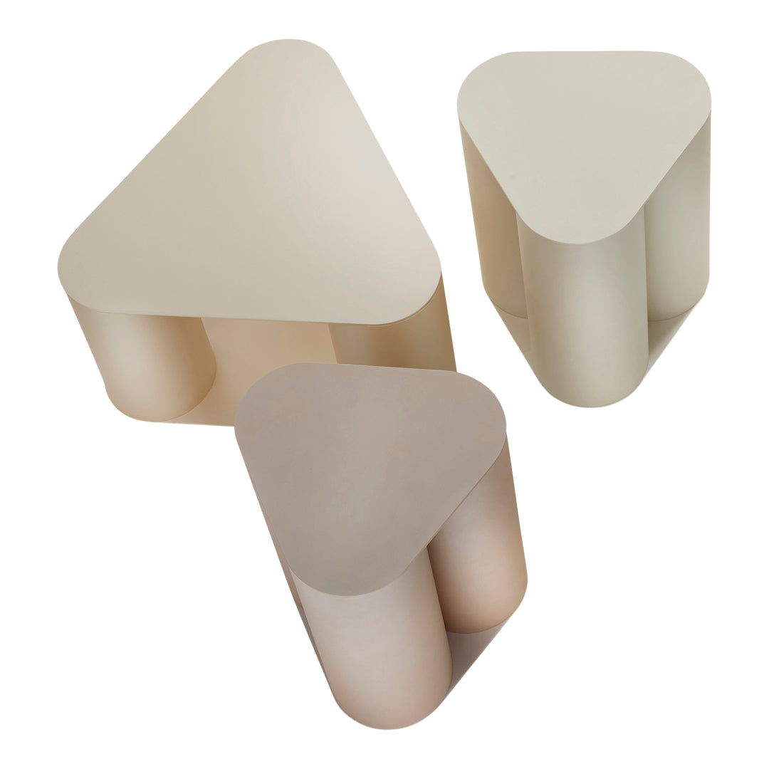 Three modern triangular tables in soft beige and taupe colors with smooth matte finishes.