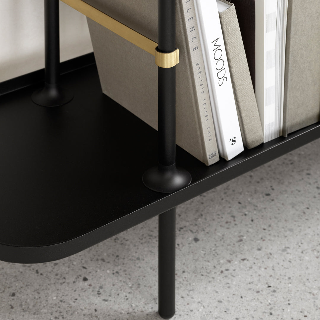 Black metal shelving unit with gold accents, showcasing a sleek, modern design and a minimalist aesthetic.