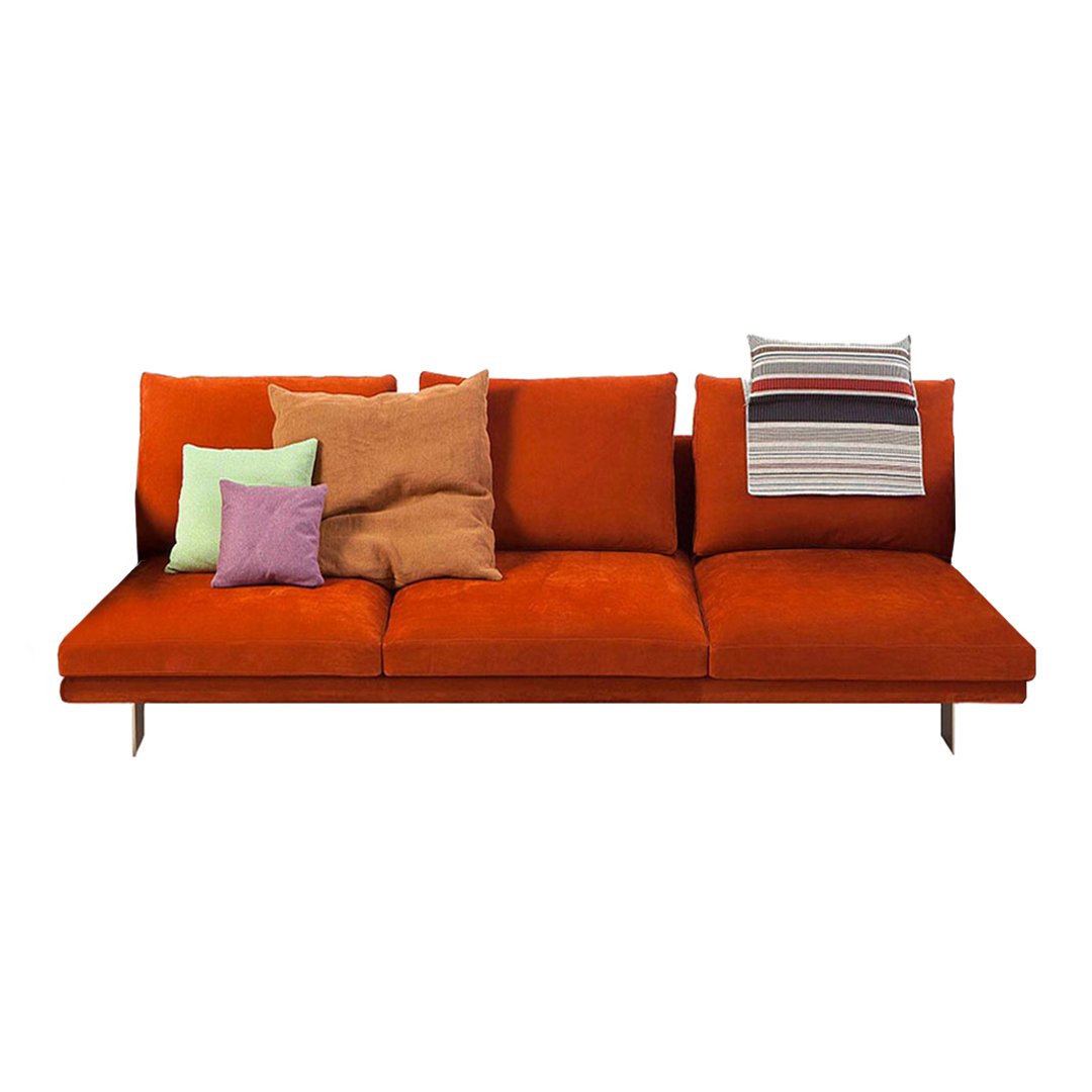 Vibrant orange sofa with textured brown and pastel pillows, featuring a striped accent for a pop of color.