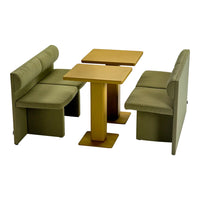 Green upholstered seating with a smooth gold table, featuring minimalist design and soft, modern patterns.