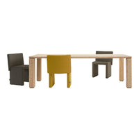 Wooden table with light brown finish. Chairs in dark gray, olive green, and vibrant yellow upholstery. Modern design.