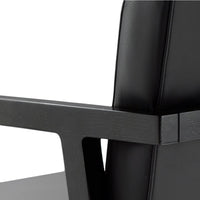 Black leather chair with a textured black wooden frame, showcasing a modern and minimalist design.